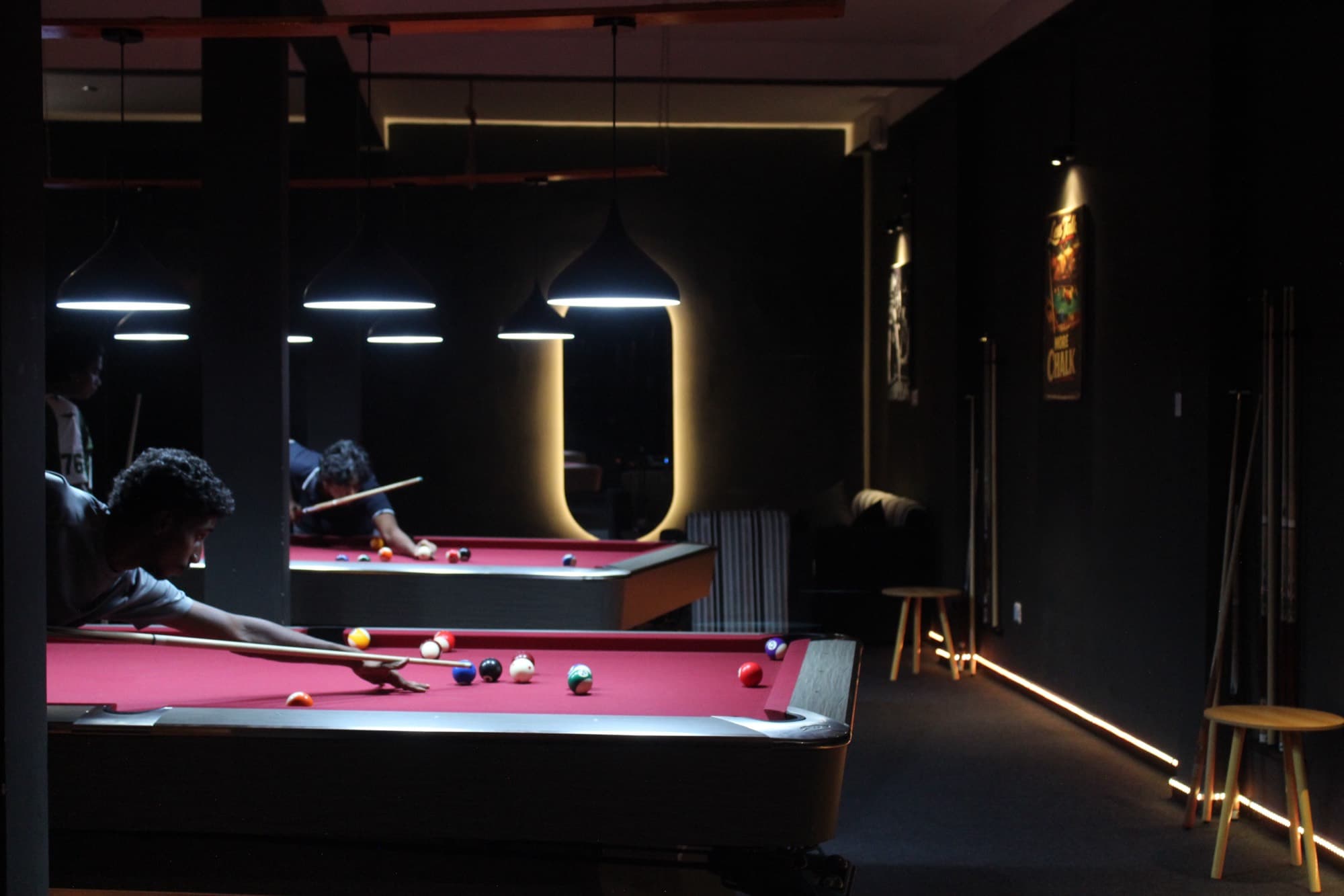 The room seen from the entrance, tables lit and waiting