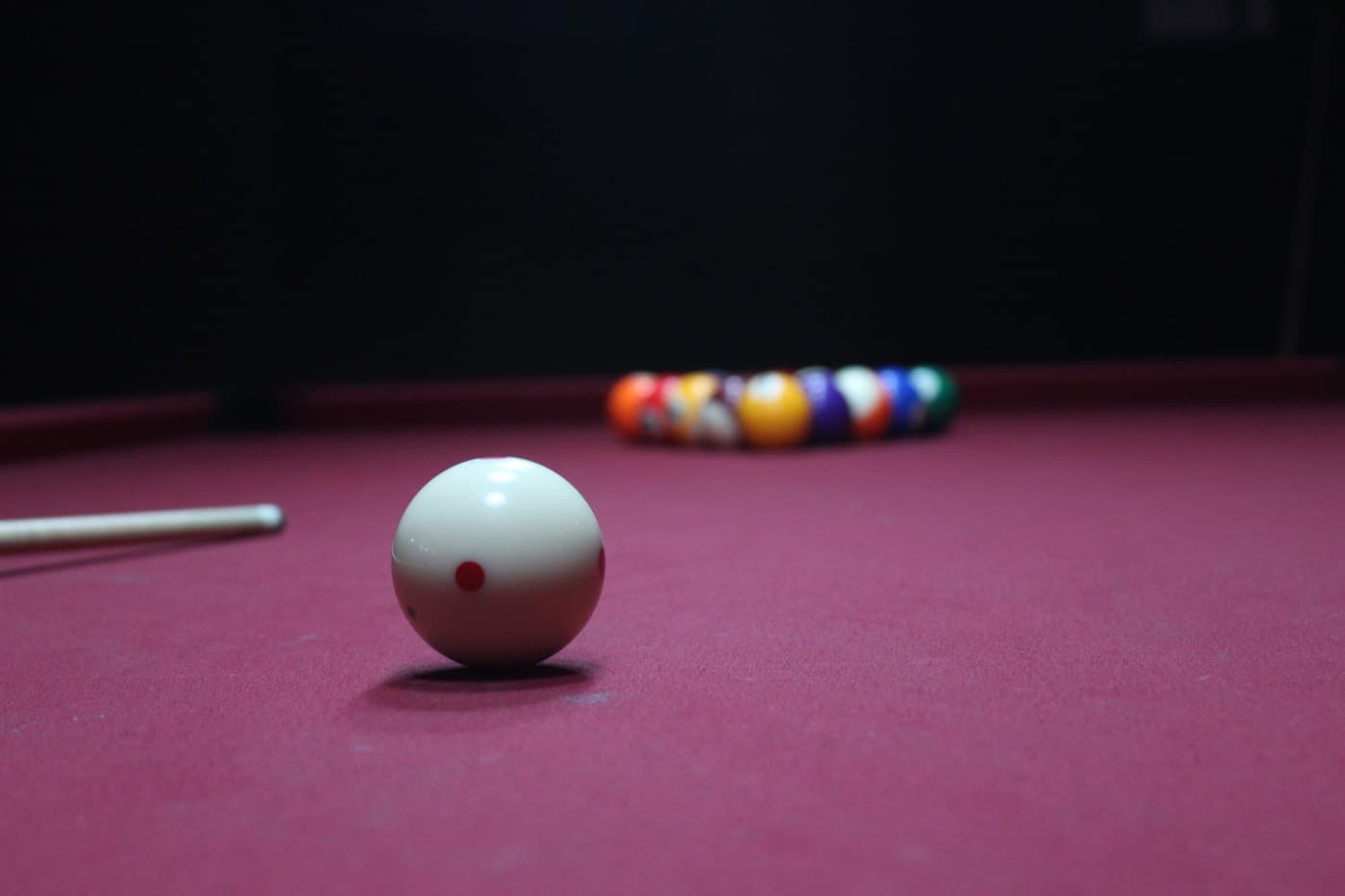 The cue ball in front of a rack of coloured balls