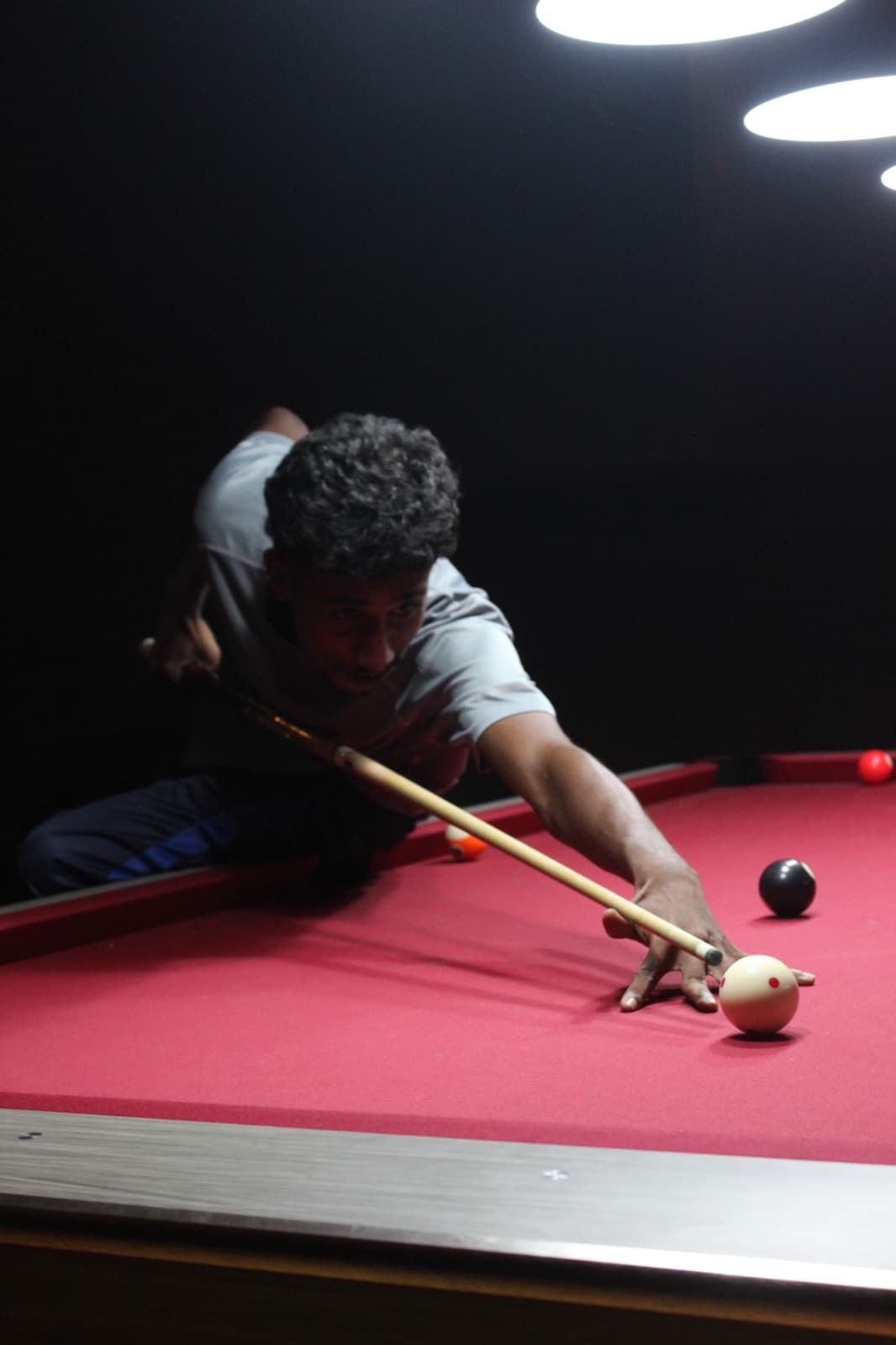 A player leaning across the table to take a shot