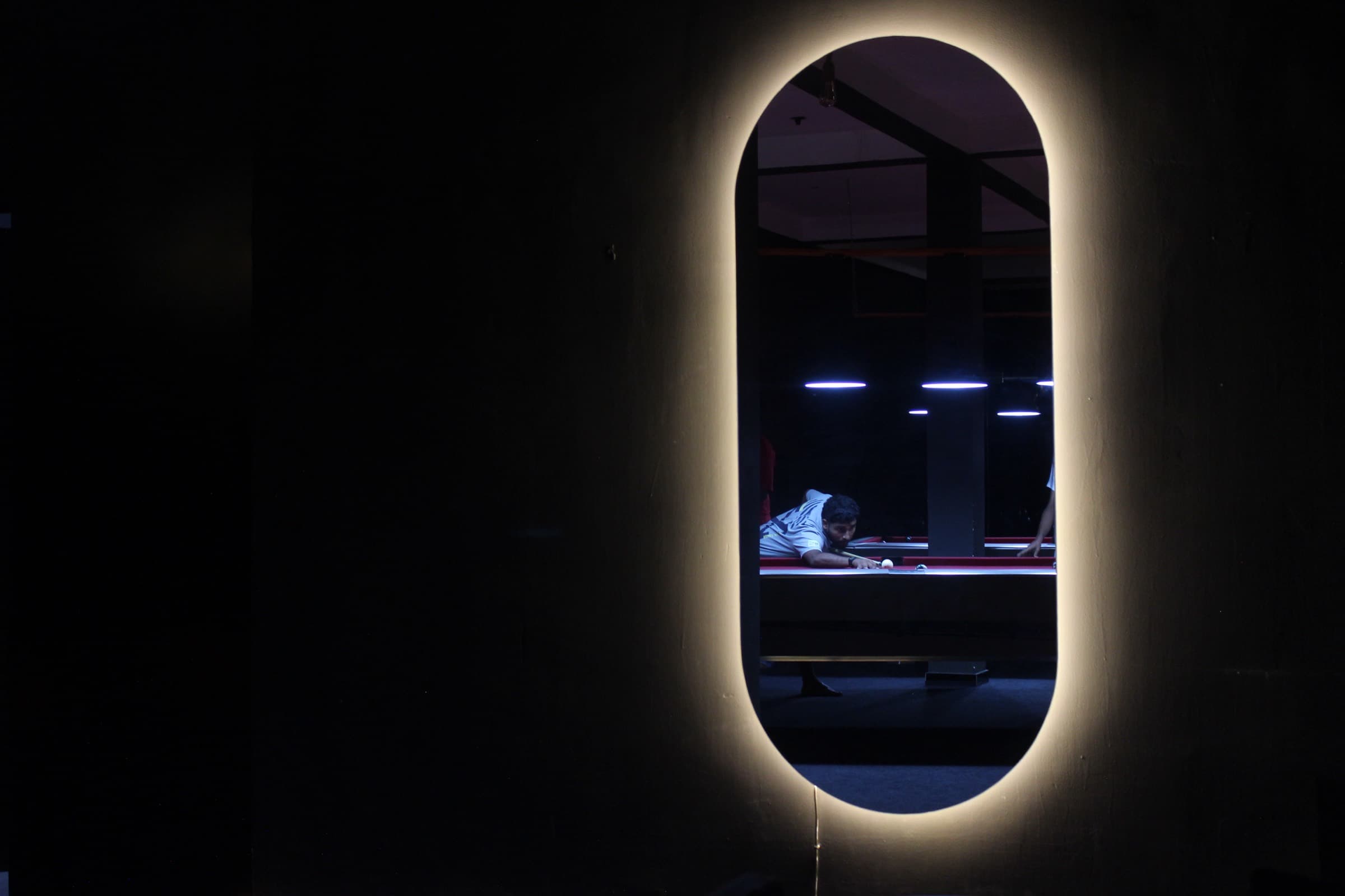 An oval wall light glowing against black