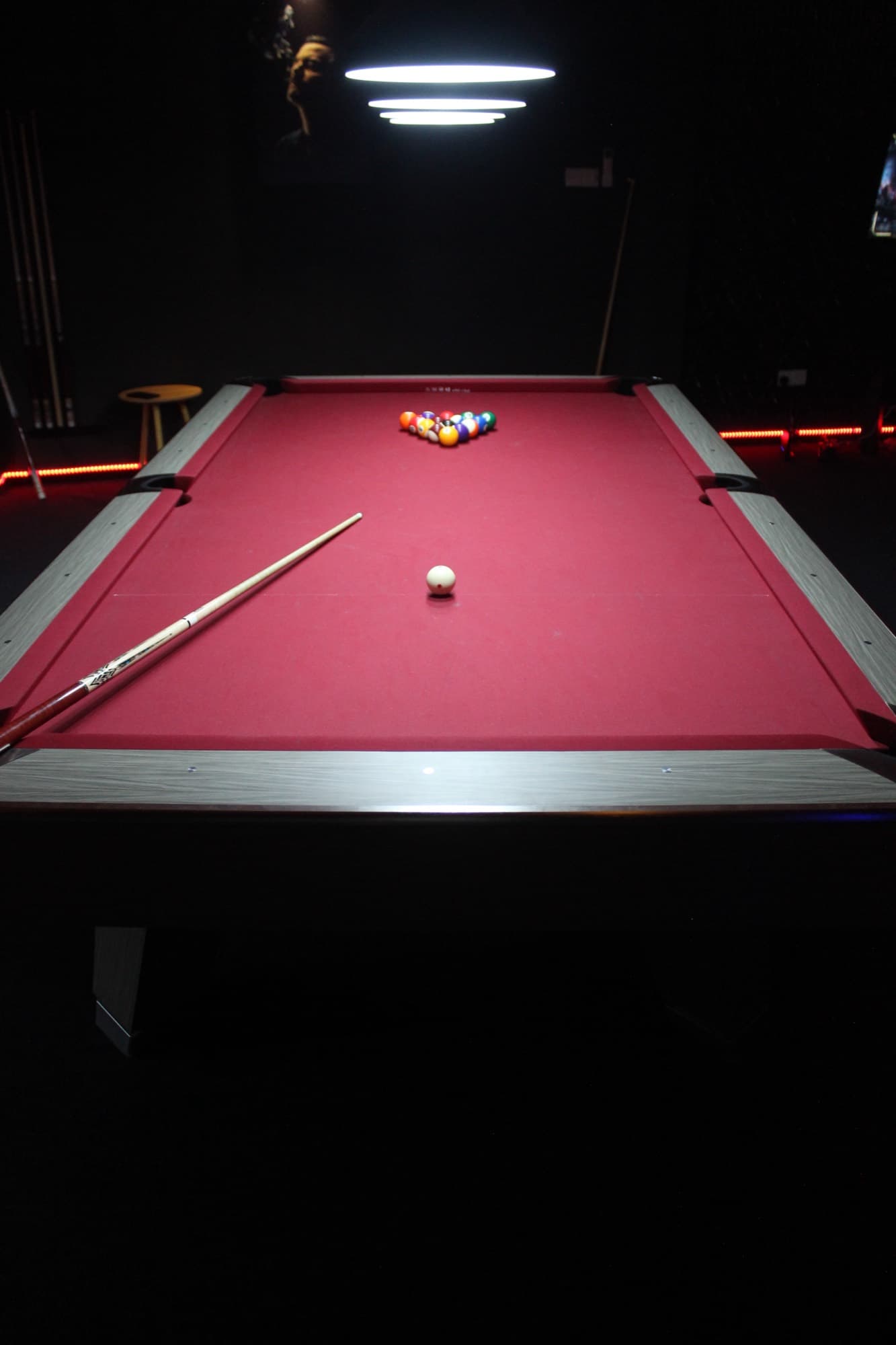 Pool tables down the length of the room under low lamps