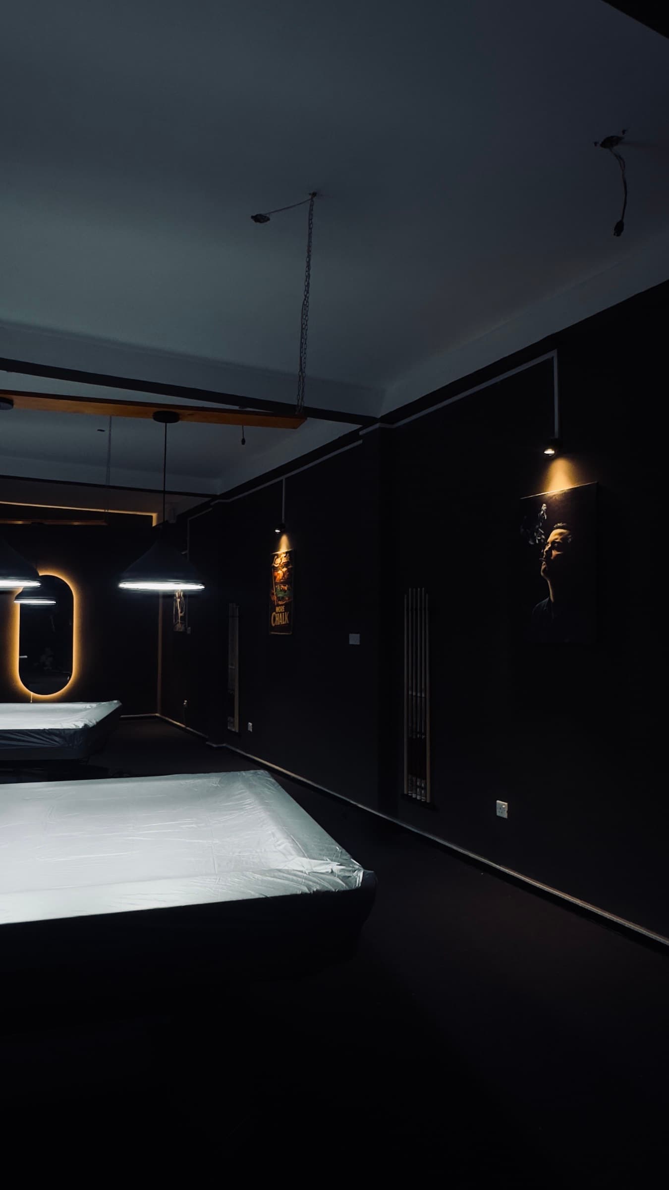 The length of the room, tables and wall lights receding into the dark