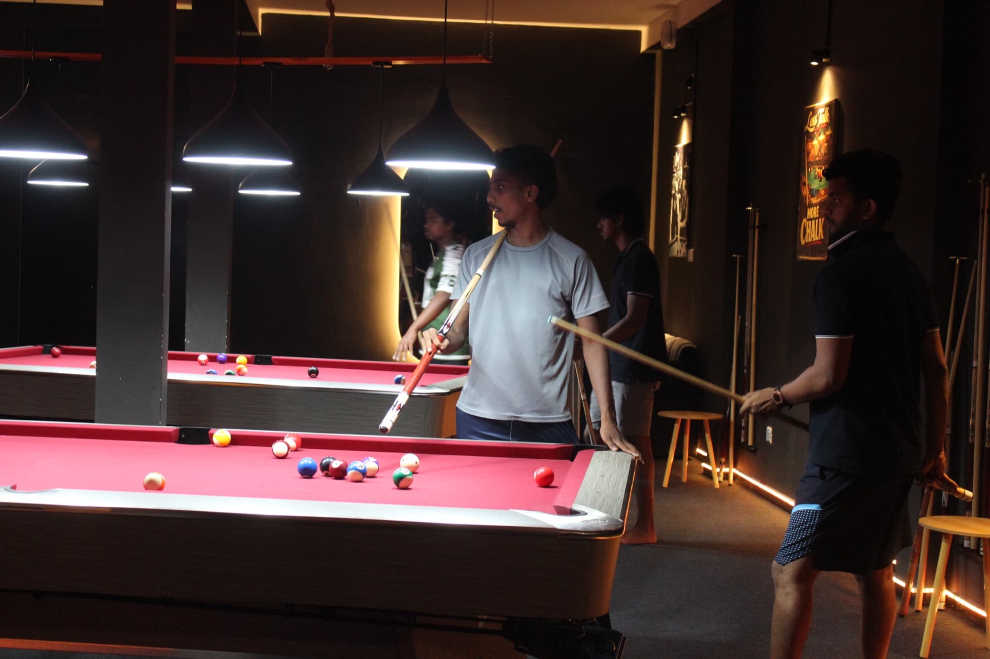Friends standing around a pool table between shots